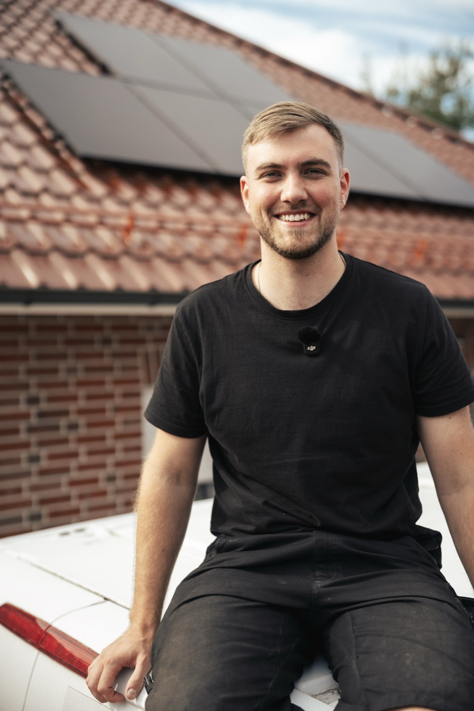 Maik Root, Geschäftsführer der Root Elektrotechnik GmbH, vor einem Haus mit Photovoltaikanlage