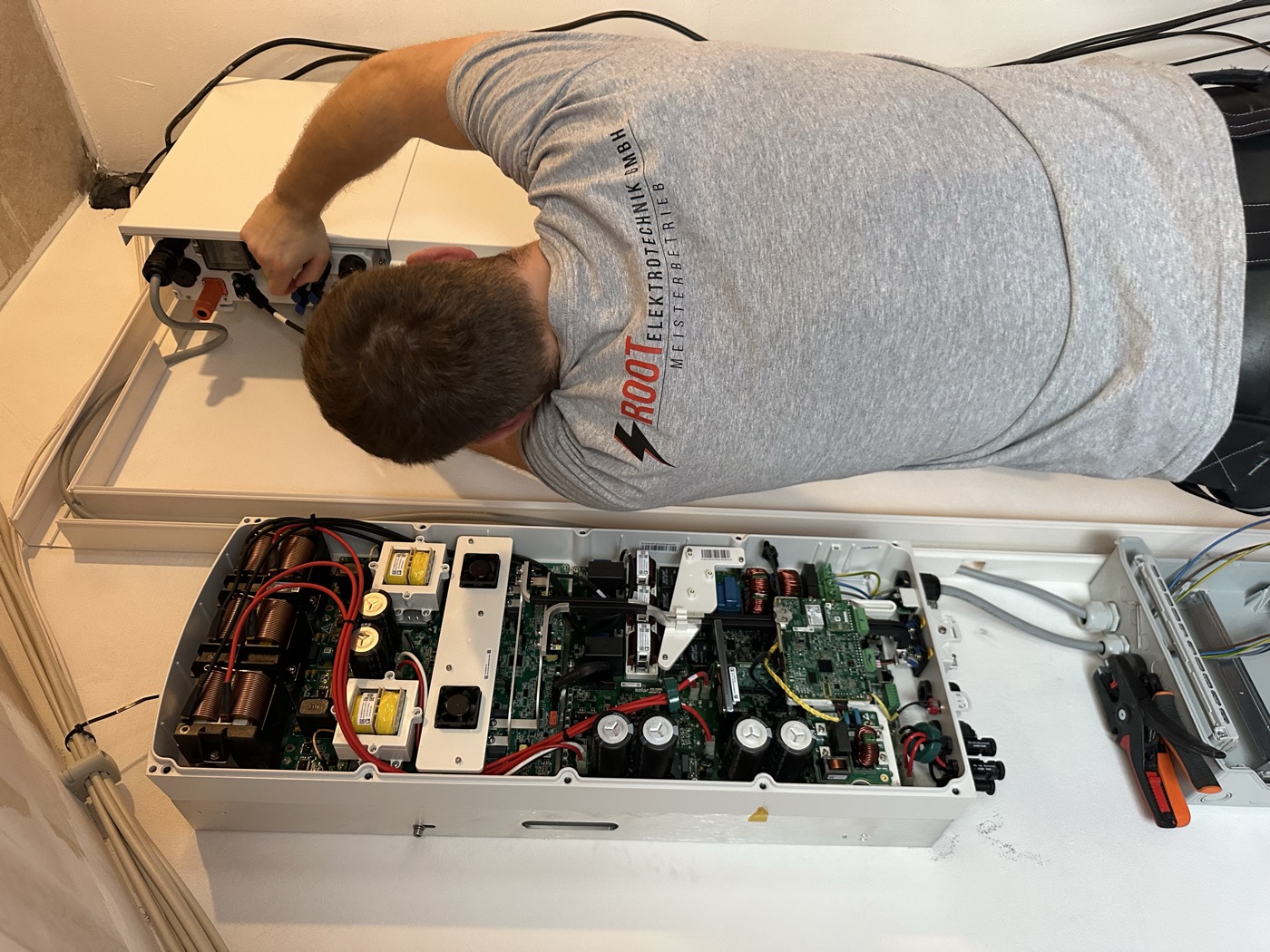 Mitarbeiter von Root Elektrotechnik beim Anschluss eines Wechselrichters für eine Photovoltaikanlage